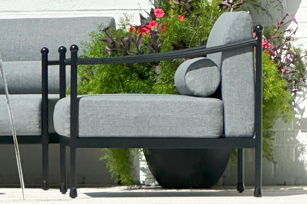 Gray outdoor sofa with black metal frame by a poolside