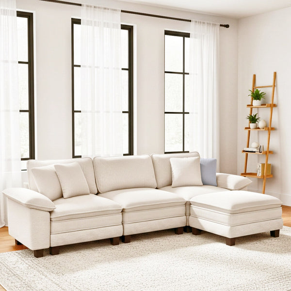 Beige sectional sofa in a living room with large windows and a wooden shelf.