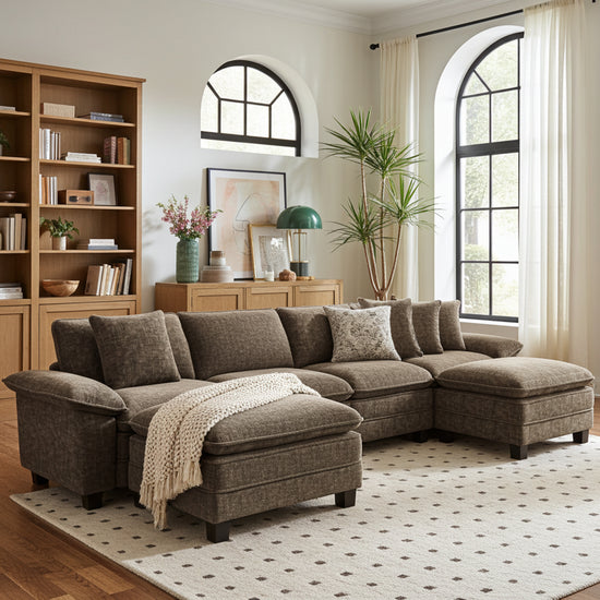 Brown large sectional sofa in a living room with bookshelves, plants, and decor.
