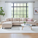 Beige sectional sofa in a living room with a large window and decorative elements.