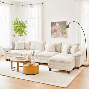 Modern living room with a white sectional sofa, wooden coffee table, and decorative elements.