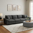 Gray sectional sofa in a living room with a rug, ottoman, and framed art on the wall.