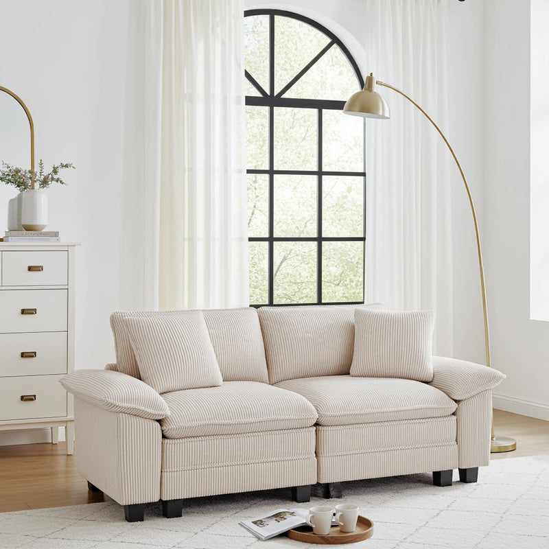 A living room couch in a room with a large window and decorative items.