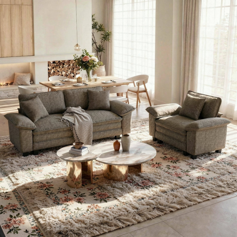 Living room with gray sofa, armchair, and coffee table on a floral rug.
