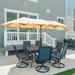 Outdoor patio set with a large beige umbrella on a deck.