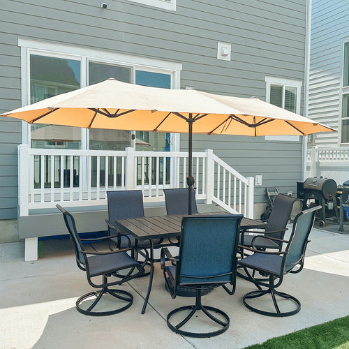 Outdoor patio set with a large beige umbrella on a deck.
