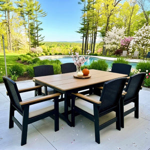 Outdoor dining set with table and chairs near a pool and garden during spring.
