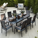 Outdoor patio set with an expandable table and chairs on a tiled patio surrounded by greenery