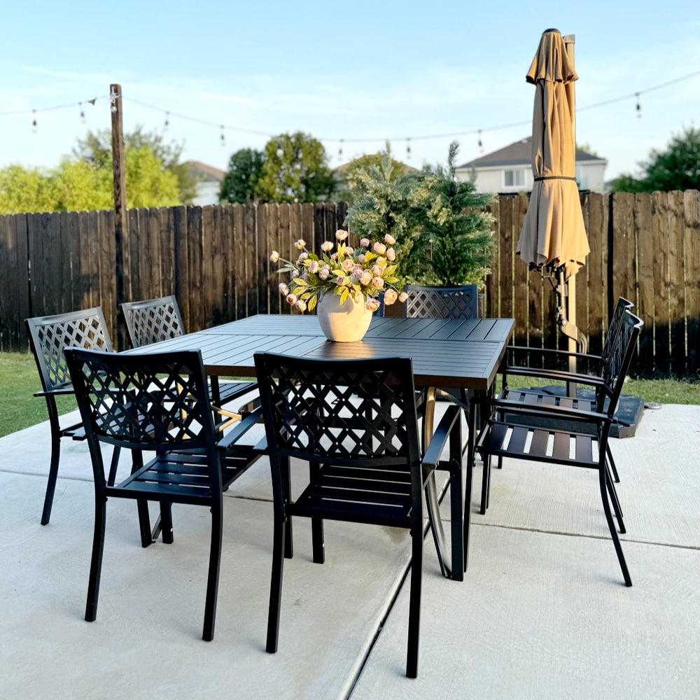 Outdoor patio set with a large square table, chairs, and an umbrella on a concrete patio.